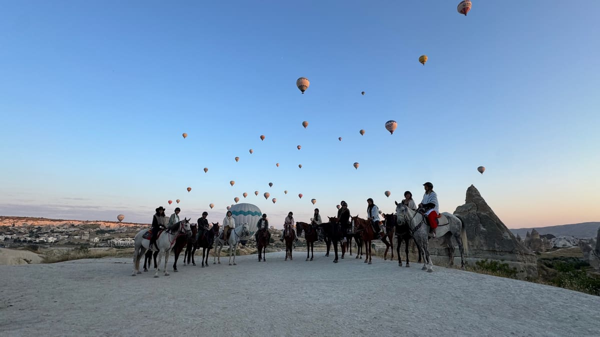 Hot air balloons rising at sunrise over the valleys of Cappadocia